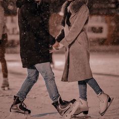 two people walking in the snow with one holding the hand of another person's hand