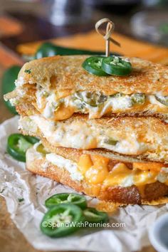 two grilled cheese sandwiches stacked on top of each other with green peppers and sauce