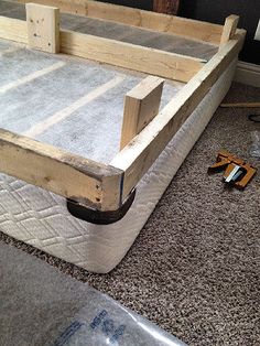 a bed frame sitting on top of a carpeted floor next to a pair of scissors