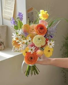 a person holding a bouquet of flowers in their hand