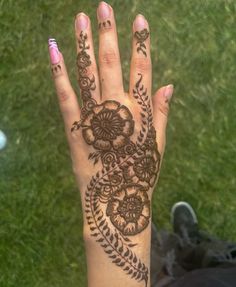 a woman's hand with henna tattoos on it