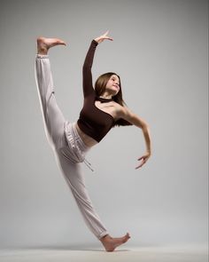 a woman is doing a yoga pose in the air with her arms stretched out and legs spread wide