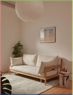 a living room with a white couch and potted plant