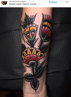 an arm tattoo with flowers on it