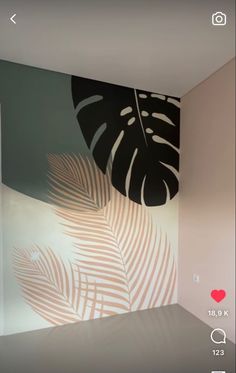 an image of a palm leaf painted on the wall in a room with white walls