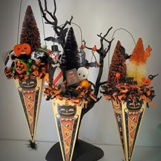 three decorative halloween vases with trees and pumpkins