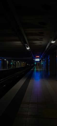 an empty subway station at night with the lights on