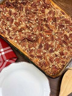 a casserole dish filled with pecans on top of a wooden table