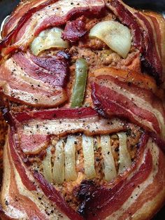 bacon wrapped in onions and peppers on top of a pan with other food items around it