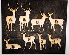 a group of deer standing next to each other on top of a wooden board with letters carved into them