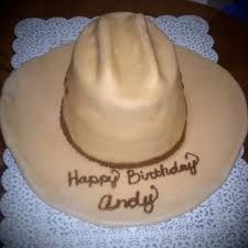 a birthday cake with a cowboy hat on it's top and the words happy birthday andy