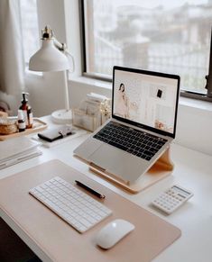 an open laptop computer sitting on top of a desk next to a mouse and keyboard