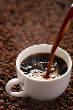 a cup of coffee being filled with liquid