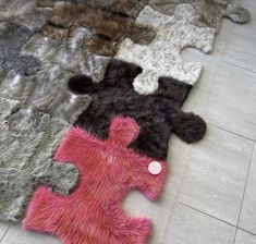 several different colored rugs on the floor with one white button in between two black and pink ones