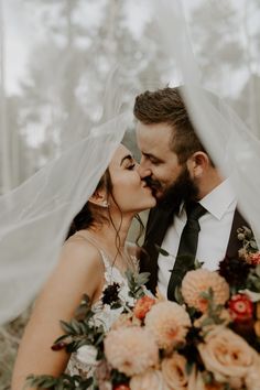 a bride and groom kissing under the veil