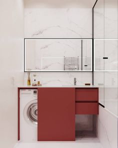 a washer and dryer in a white bathroom with red cabinetry on the wall