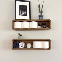 two wooden shelves holding toilet paper and other items