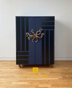 a blue cabinet sitting on top of a hard wood floor next to a white wall