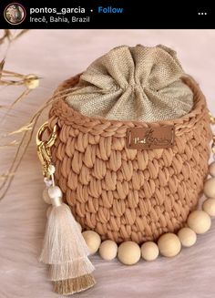 a small woven bag with tassels and beads on the bottom is sitting on a table