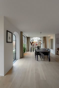 a dining room with wooden floors and white walls