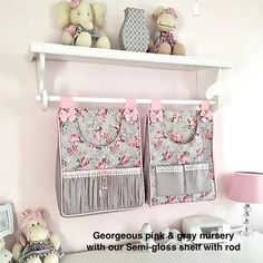 two pink and gray curtains hanging on the wall above a white desk with teddy bears