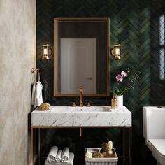 a bathroom with a marble sink and gold fixtures