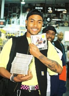 a man holding up a stack of books in front of his face and smiling at the camera