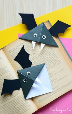 an open book with some paper bats on it