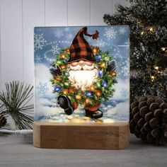 a glass block with an image of santa claus holding a wreath on top of it