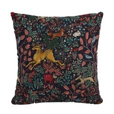 an embroidered pillow with horses and flowers on black fabric, in front of a white background