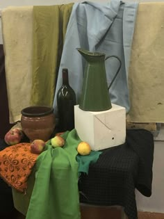 an arrangement of fruit and vases on a table