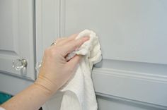 a person wiping their hands with a towel on the door knobs in front of them