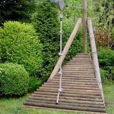 a set of stairs made out of wooden planks in the middle of a garden