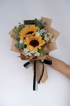 a bouquet of sunflowers wrapped in brown paper