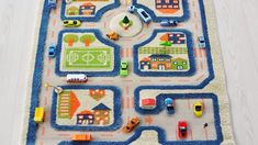 a child's rug with cars and houses on it