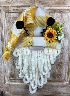 a door hanger with a yellow and white striped hat on it's face