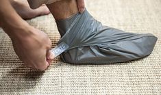 a man is wrapping his foot with a plastic shoe cover