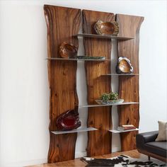 a wooden shelf with several bowls and vases on it in the corner of a room