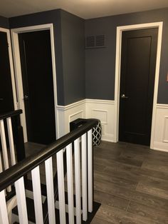 an empty room with black doors and white railings