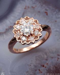 a diamond ring is shown on top of a marble surface with snow flakes in the background