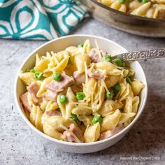 two bowls filled with pasta, peas and ham