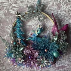 a blue and purple christmas wreath on a bed