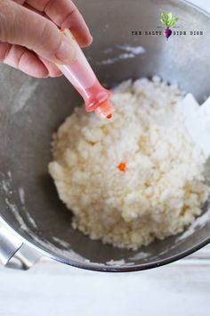 someone is stirring rice in a bowl with a spoon