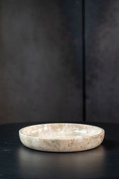 a marble bowl sitting on top of a black table