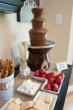 chocolate fountain with strawberries, strawberries and marshmallows on the table