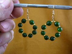 (Internal #EE-800-24) This is a beautiful pair of 8 bead faceted GREEN JADE, 8 mm, hoop loop dangle circle earrings with gold brass spacer beads and gold color hypoallergenic French wires.  Hoops are 1-1/4" diameter.  This is exactly what you would receive. WE SHIP WORLDWIDE!  Other accepted payment: Credit card (Mastercard\/Visa\/Discover) inquire for details. Gift Gemstone Beads Hoop Earrings, Round Gemstone Beads Hoop Earrings As Gift, Round Faceted Beads Earrings As Gift, Gold Earrings With Gemstone Beads, Jade Jewelry With Round Spacer Beads, Stamp Jewelry, Silver Brooch Pin