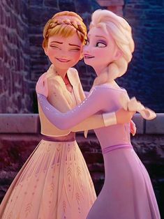 two frozen princesses hugging each other in front of a brick wall and stone building