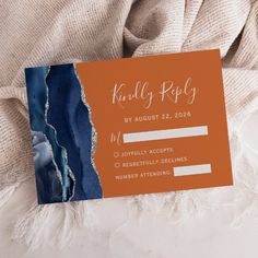 an orange and blue wedding card on top of a white blanket with the words, killly popy by august 22, 2016