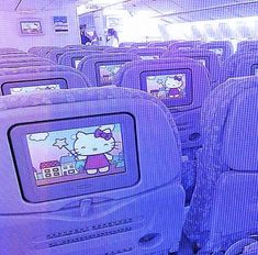 an airplane with hello kitty pictures on the screen and people in the back seat looking at them