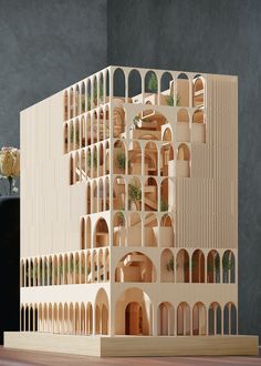 a model of a building made out of wood with plants growing on the top floor